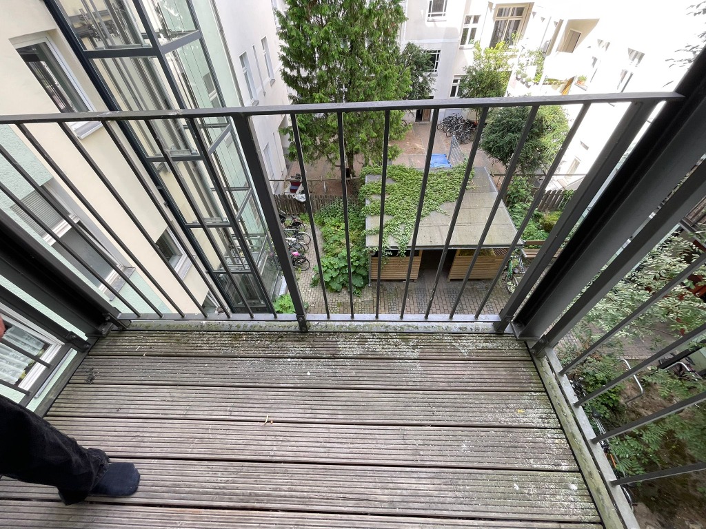 Balkon mit verwittertem und befallenem Holzboden vor der Reinigung